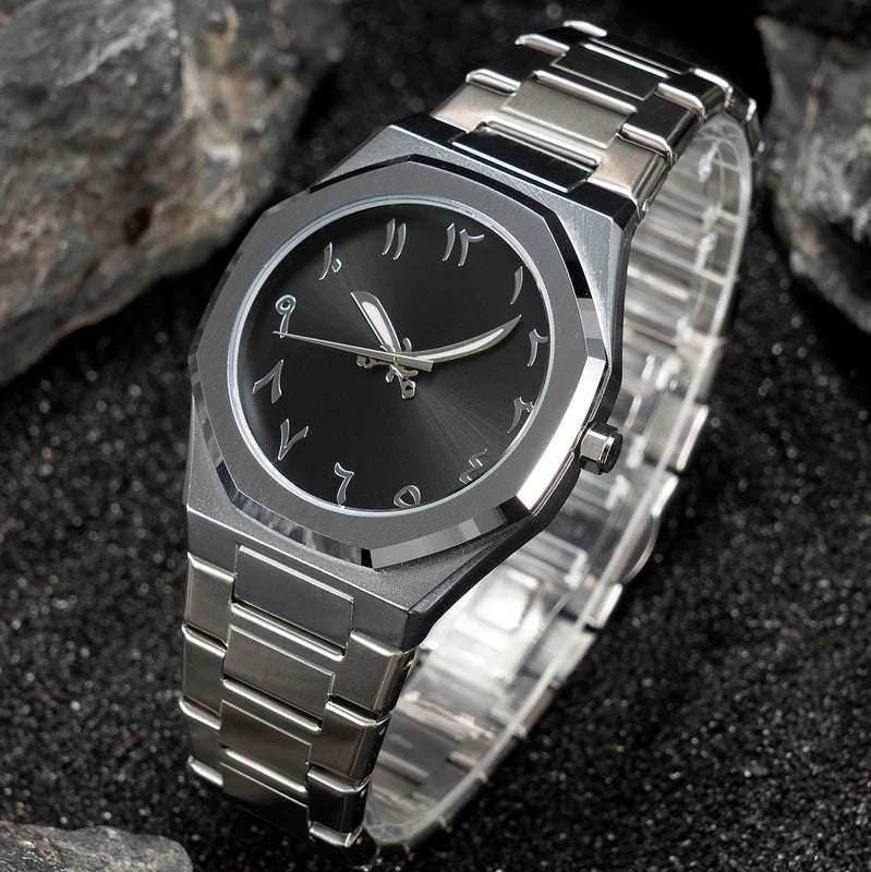 Silver watch with black face on a dark textured background