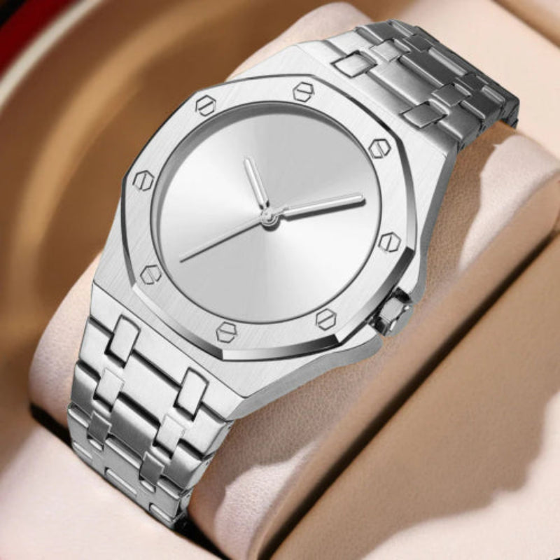 Silver watch with a metal band on a wrist against a neutral background