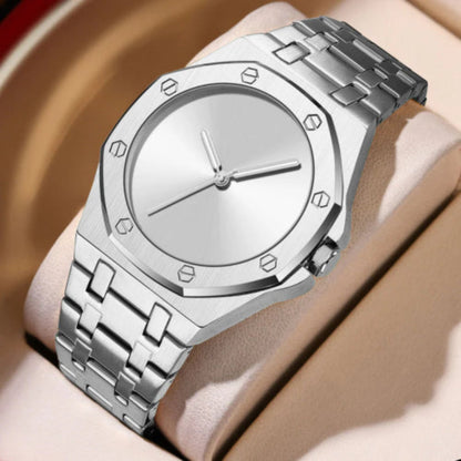 Silver watch with a metal band on a wrist against a neutral background