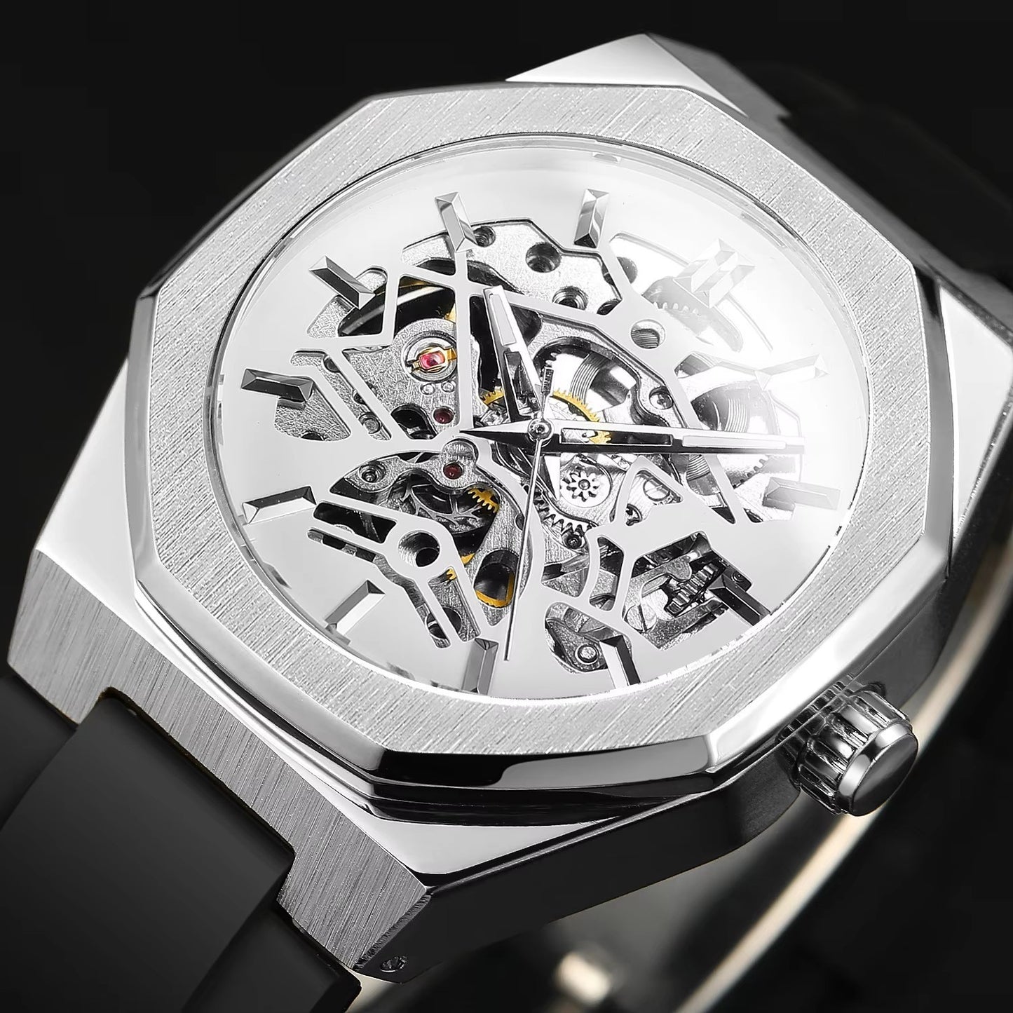 Silver skeletonized watch with black strap on a dark background