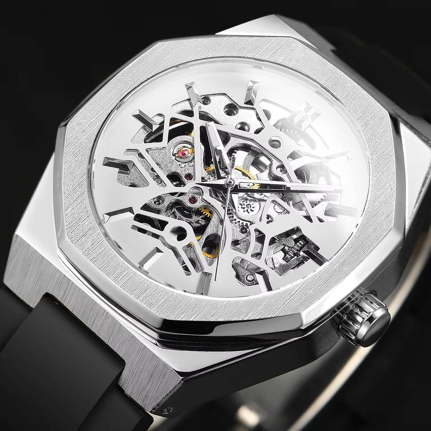 Silver skeletonized watch with black strap on a dark background