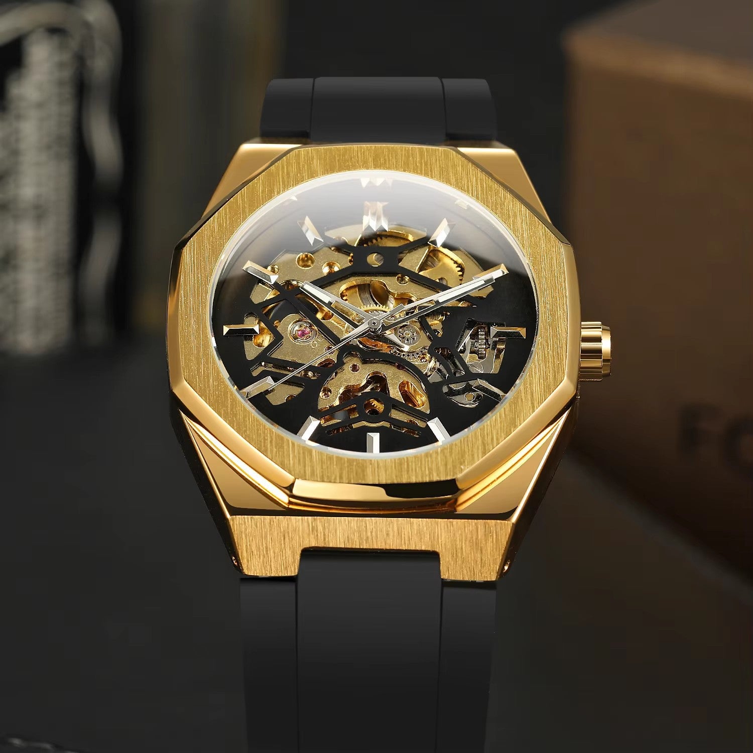 Gold mechanical watch with black strap on a dark background